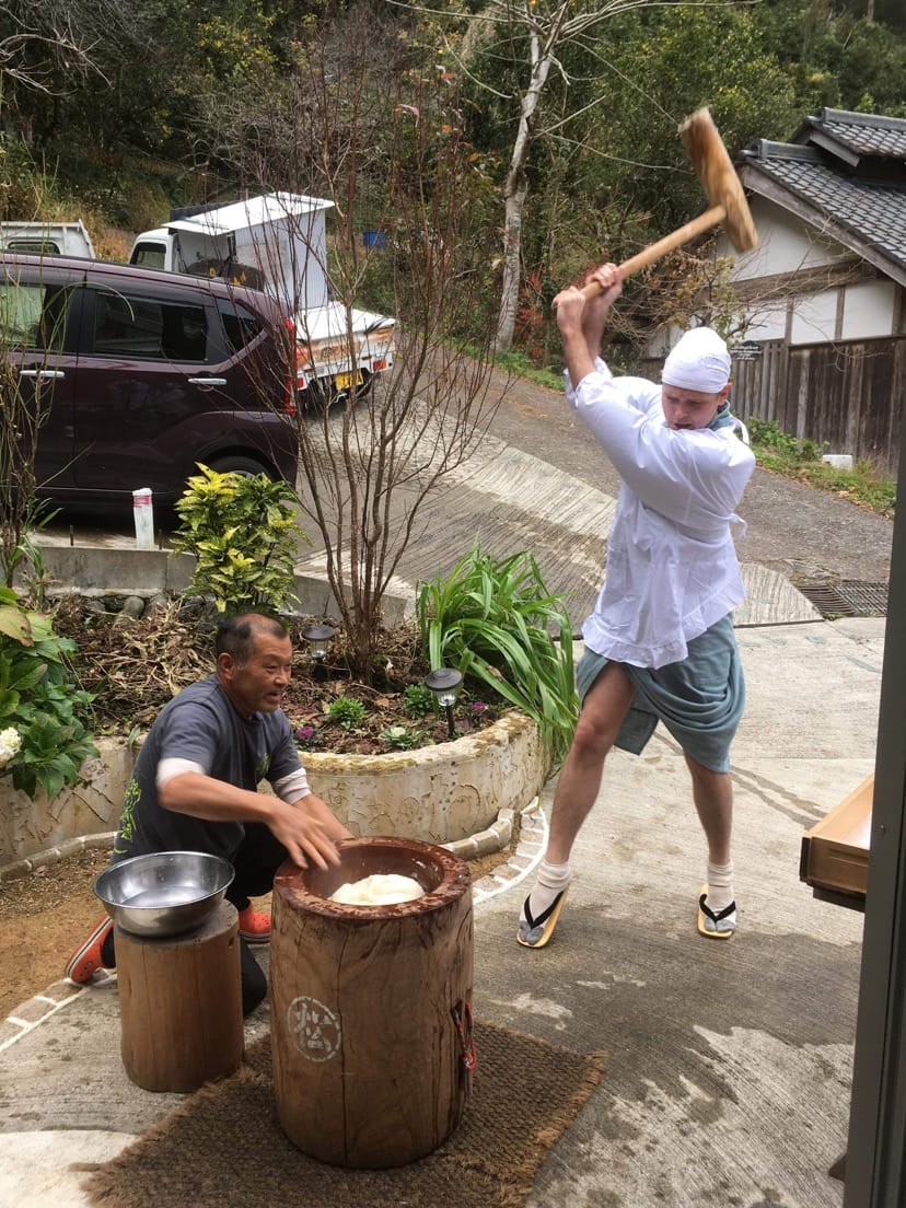 杵を振り上げてもちをつく体験参加者