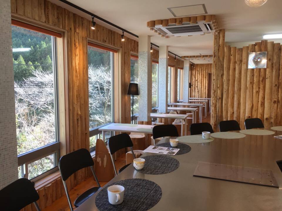 木の壁と大きな窓が印象的なカフェの店内
